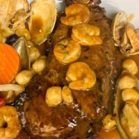 Shell Steak A Marinheira · grilled shell steak topped with clams, mussels, shrimp, and scallops