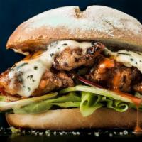 Buffalo Chicken Burger · Our delicious spicy buffalo chicken patty with a black-and-blue melted cheese on a warm butt...