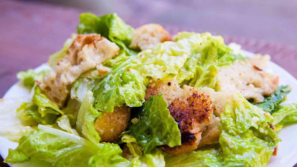 Chicken Caesar Salad · Romaine lettuce tossed in a creamy Caesar dressing, topped with grilled chicken, croutons and Parmesan cheese