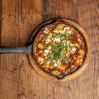 Shakshuka · Gluten-free. Two eggs poached in a spicy tomato sauce. Feta cheese, olives, zaatar, with pit...