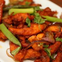 Chicken 65 · Marinated chicken stir-fried with curry leaves, onions, and peppers.