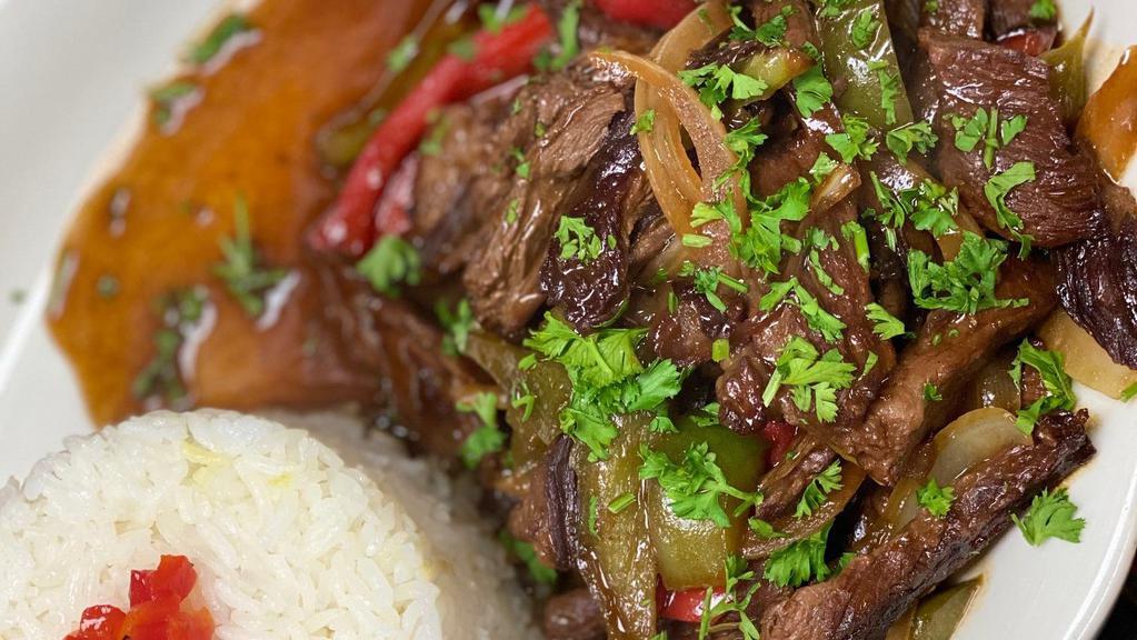 Lomo Saltado · Skirt steak strips sauteed with red onion, tomatoes, and cilantro. Served with rice and fries.