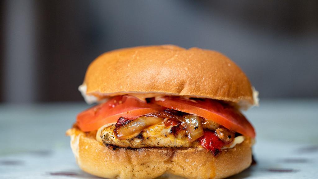 Cajun Grilled Chicken Burger · Boneless chicken breast with Cajun seasoning, topped with roasted red peppers, sautéed onions, pepper jack cheese and fresh tomato slices on a deli bun with chipotle sauce and chipotle mayo.