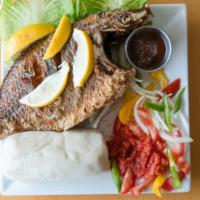 Grilled Tilapia (5 Loaves Entrée – 4) · Marinated with onions, ginger herbs, vegetables, and spices. Served with banku.