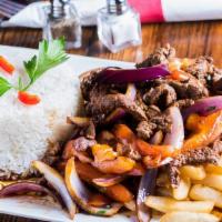 Lomo Saltado · Filet mignon chunks sauteed with soy sauce, onions, tomatoes, cilantro and French fries. Tra...