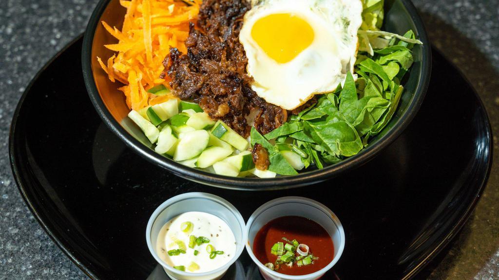 Bulgogi Bibimbap · Rice topped with Korean style marinated beef, mixed vegetables, and fried egg. Hot and sweet Korean sauce with sesame oil on the side.