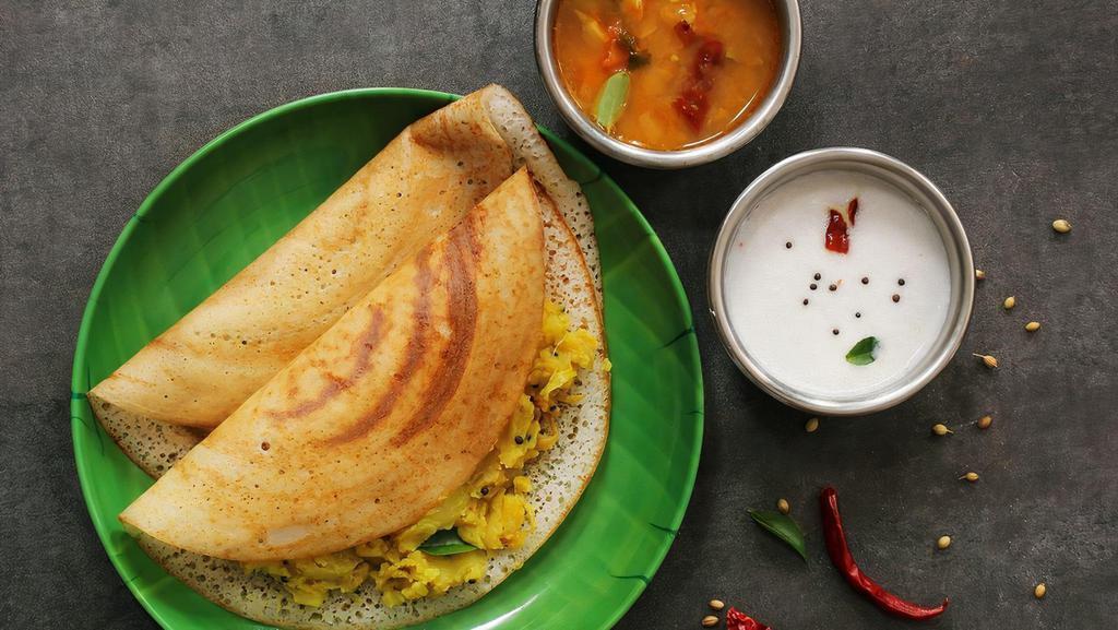 Masala Dosa (Gf, Vegan) · Dosa served with a mildly spiced potato filling with different options.  A dosa is a savory thin crepe made from a fermented batter of rice and black lentils. Dosas are naturally gluten free. Served with sambar and chutneys.