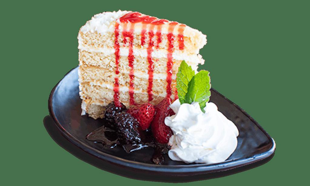 Lemon Cream Cake · A towering slice of lemon cake with white chocolate lemon mousse, topped with tangy lemon curd, served with triple berry sauce.