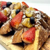 Banana Foster French Toast · Spread with Nutella, garnish with fresh berries, maple syrup & lemon ricotta.