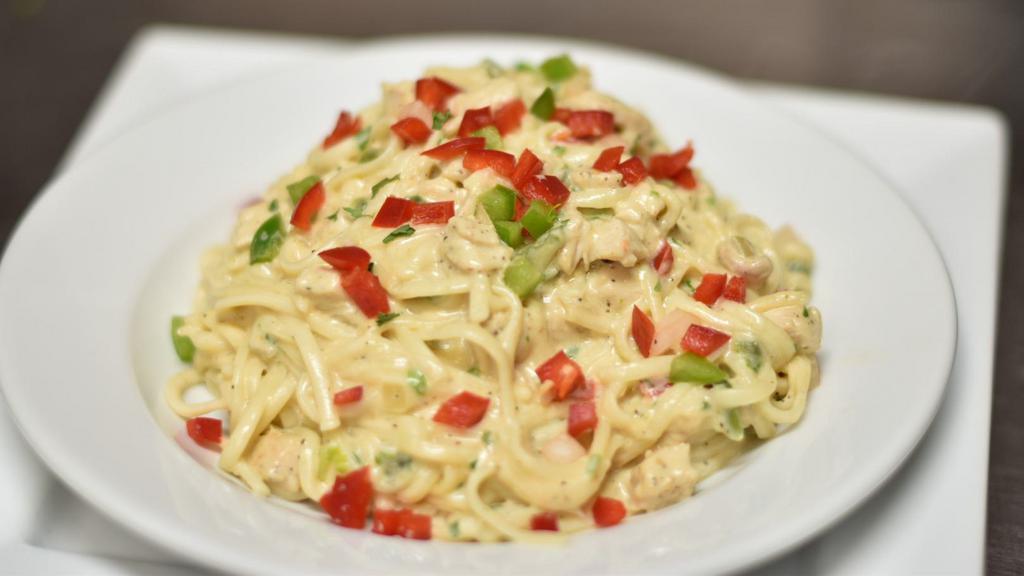 Chicken Alfredo Pasta / Pasto Pollo Alfredo · A flavorful and juicy chicken breast in a freshly made fettuccine alfredo pasta topped with parmesan cheese.