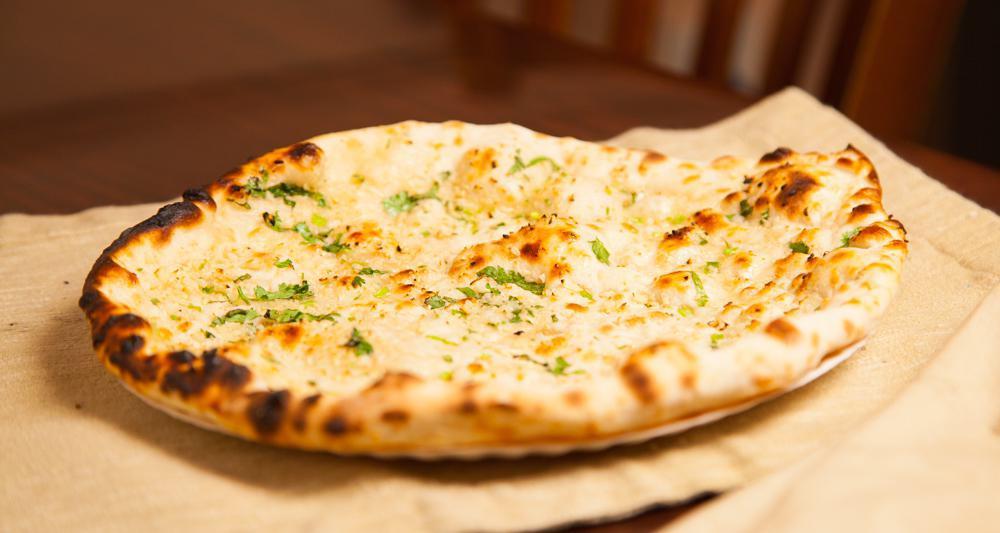 Garlic Naan · Leavened bread of super fine flour with garlic baked in a clay oven.
