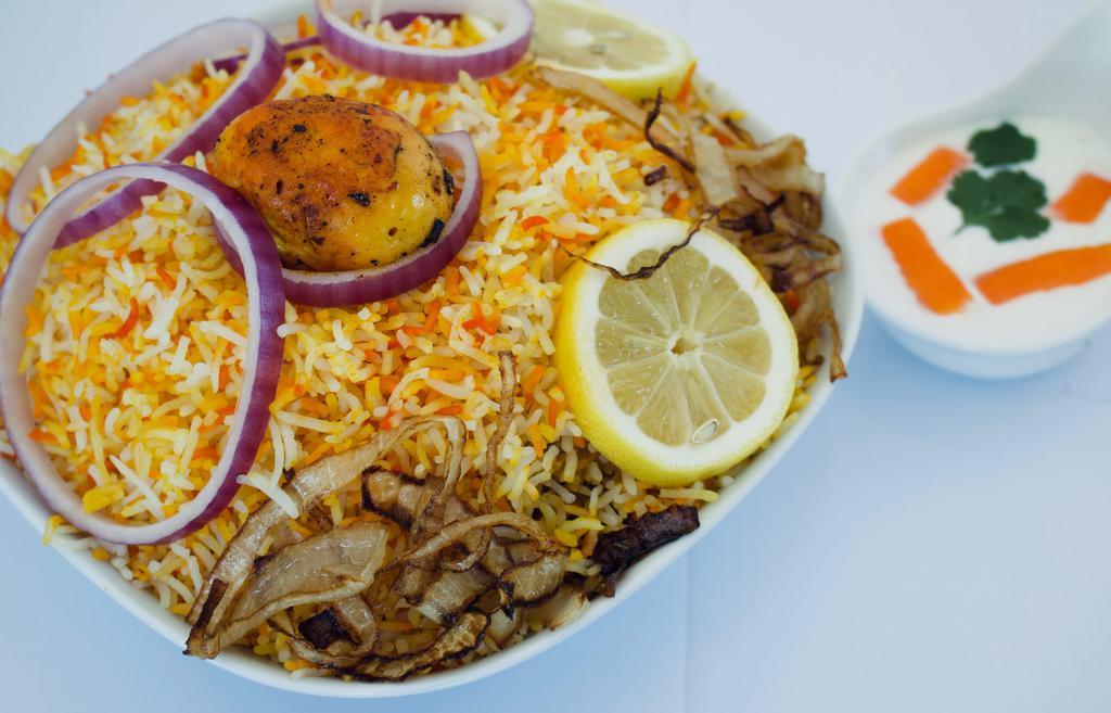 Chicken Biryani · Long grain basmati rice flavored with saffron and cooked with chicken in a delicate blend of exotic spices and herbs.