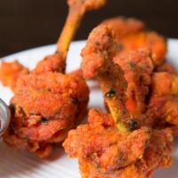 Chicken Lollypop (4 Pieces) · A fun chicken wing appetizer, the secret is a red-tinged marinade of garlic, Chile and soy.