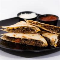 Steak Quesadilla · Grilled top round steak, tomatoes, and cheddar jack cheese. Served with a side of sour cream.