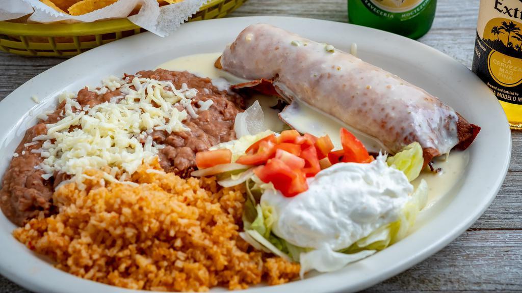 Chimichangas · Two flour tortillas, soft or fried filed with shredded beef chicken, topped with cheese sauce served with guacamole salad, rice and beans.