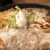 El Burrito Ranchero · Two burritos filled with fried chicken and cheese, topped with cheese sauce, burrito sauce, ...