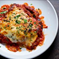 Chicken Parmigiana · Hearty chicken covered with savory marinara sauce and creamy cheese and served with side dis...