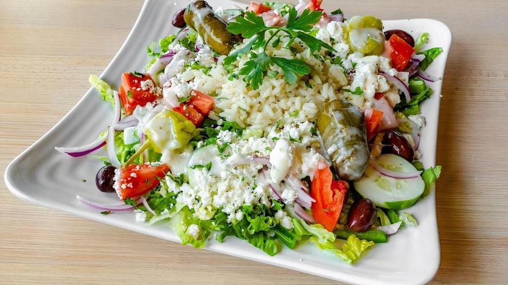 Greek Rice Bowl · a nest of our classic Greek salad topped with a large scoop of our homemade rice pilaf. *GF**VEGETARIAN*. *VEGAN without the feta/dressing substituted for oil and vinegar*