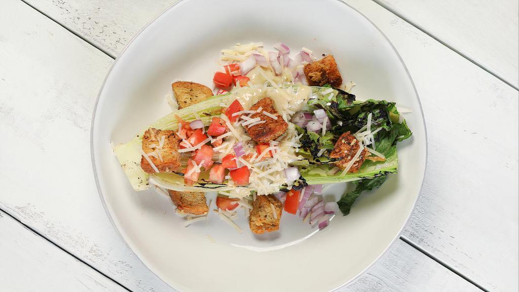 Grilled Caesar · Grilled romaine lettuce, Parmesan cheese, tomatoes, red onions, truffle Parmesan croutons, and homemade caesar dressing.