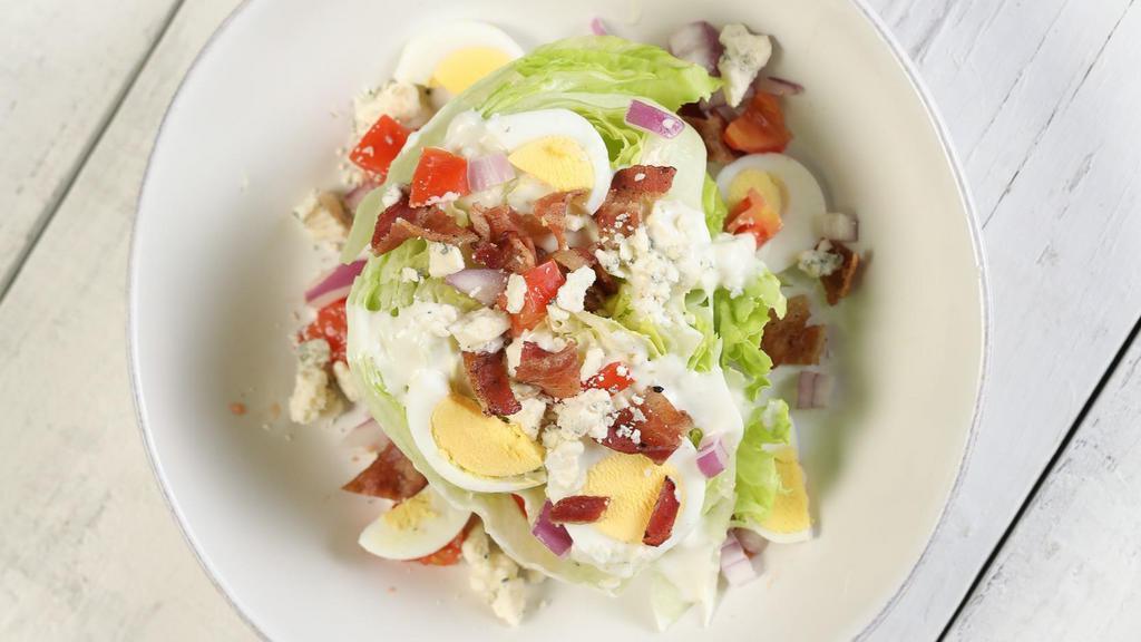 Wedge · Iceberg lettuce, bacon bits, blue cheese crumbles, tomatoes, red onions, hard boiled eggs, and blue cheese dressing.