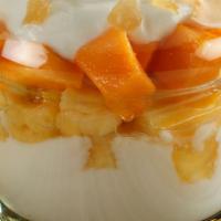 Tropical Yogurt Parfait · Delicious yogurt parfait topped with fresh pineapple, mango, coconut flakes and granola.