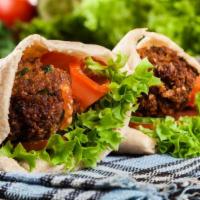 Falafel On Pita · Fresh crispy falafels made from chickpeas rolled into a ball and fried topped with chef's sp...