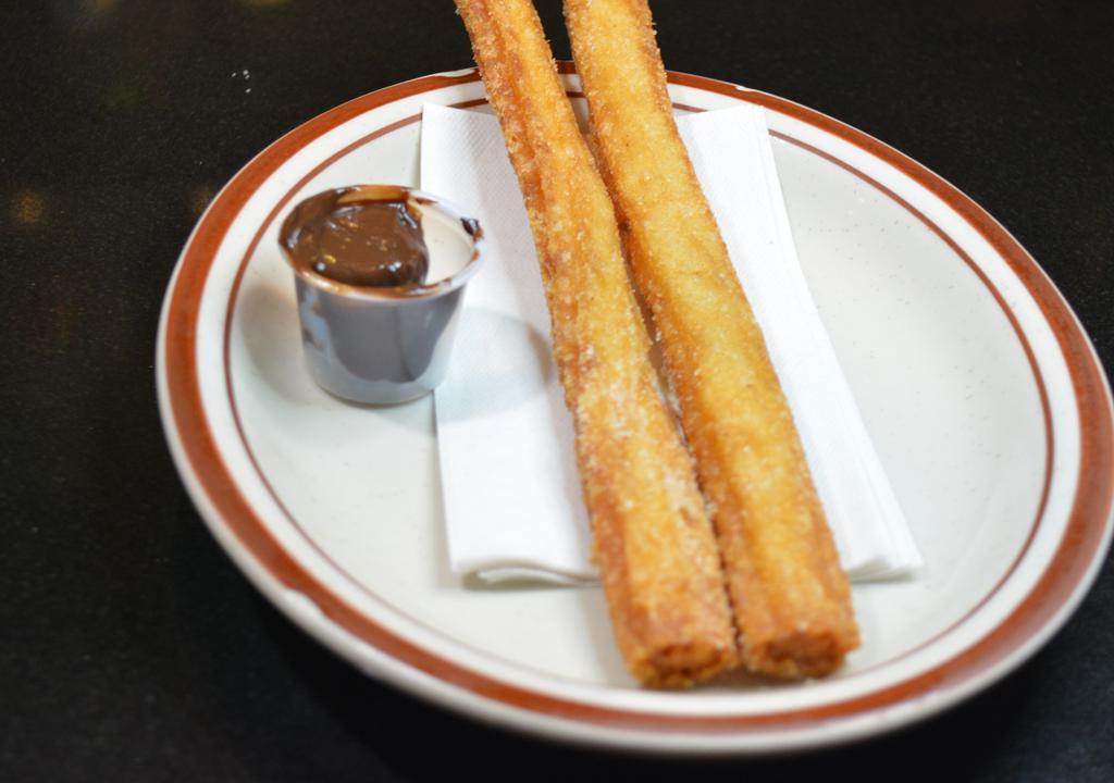 Churros · Two fried churros coated in sugar with dipping chocolate