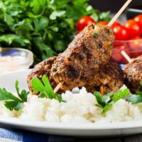 Beef Kofta Over Rice · House-made beef kofta kabobs on spiced rice. Served with lettuce, tomatoes, onions and peppe...