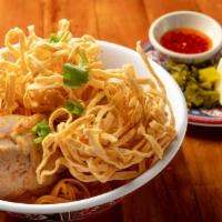Khao Soy · Soft thick noodle with chaing Mai style coconut curry sauce, chicken drumstick topped with c...
