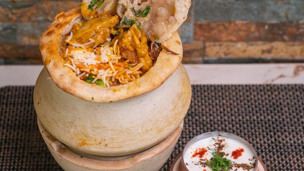 Chicken Biryani · An exotic blend of basmati rice, assorted vegetables and traditional spices and herbs, layered with chicken. Served with Raita.
