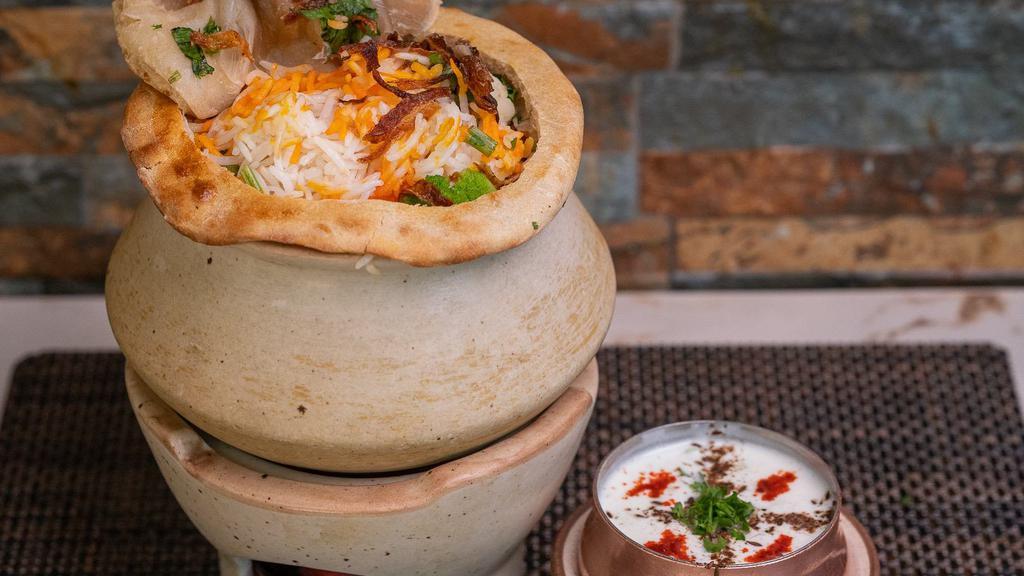 Goat Biryani · An exotic blend of basmati rice, assorted vegetables and traditional spices and herbs, layered with goat. Served with Raita.