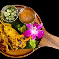 Chicken Satay · On skewers with peanut sauce and cucumber salad.