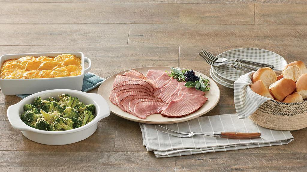 By-The-Slice Suppers - 1 Lb. Ham · Serve our new By-The-Slice Suppers any night of the week! This meal features 1 lb. of Honey Baked Ham slices that are always moist and tender. Our slices are ready to serve, hand-cut from our signature bone-in ham which is slow-smoked for up to 24 hours and handcrafted in store with our sweet and crunchy glaze. Also included with this meal are two frozen Heat & Serve side dishes - our Cheesy Potatoes au Gratin and Green Bean Casserole (simply bake or microwave those) and a package of King's Hawaiian rolls. Serves 2-4.
