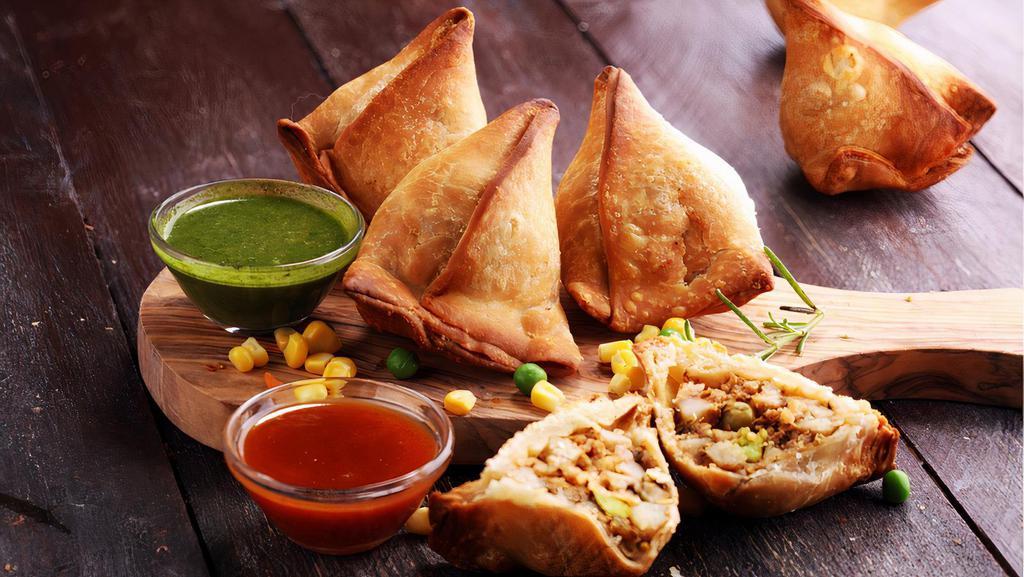 Famous Indian Chicken Samosa · 3 Pcs. Hot fried pastry shells stuffed with roasted minced chicken and cumin potatoes, served with mint and tamarind chutney.