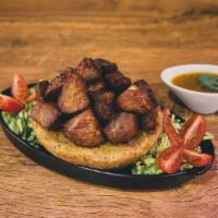 Mofongo De Carne Frita · Fried green plantains mashed together in a pilón with salt, our homemade broth, garlic & oli...