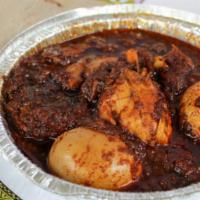 Doro Wot · Two drumsticks slow-cooked in a dense stew of onions, berbere, and kibe with a small boiled ...