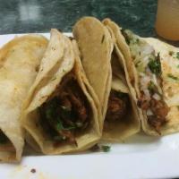 Al Pastor Taco · Soft tortilla filled with al pastor and topped with onions and cilantro, served with lime on...