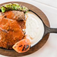 Iskender · Sautéed buttered bread topped with yogurt over sliced doner and tomato sauce.