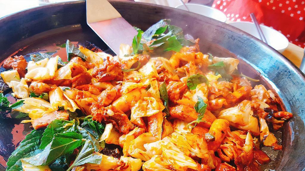 Spicy Stir-Fried Chicken · A spicy stir-fried chicken dish made with boneless chicken pieces, rice cakes (tteokbokki tteok), green cabbage, and other vegetables. Comes with a bowl of rice.