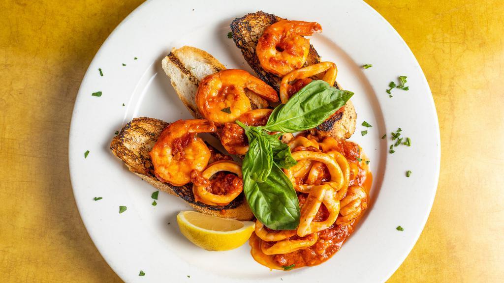 Calamari E Gamberi Fra Diavolo · Calamari and shrimp in a spicy red sauce served with thin sliced toasted seasoned bread.