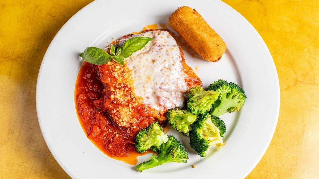 Eggplant Parmigiana · Eggplant breaded and baked with tomato sauce, mozzarella and grated parmigiano served with a vegetable and potato croquette.