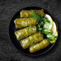 Ottoman Dolma · Grape leaves stuffed with  vegetables, rice, herbs & spices served over a bed of salad