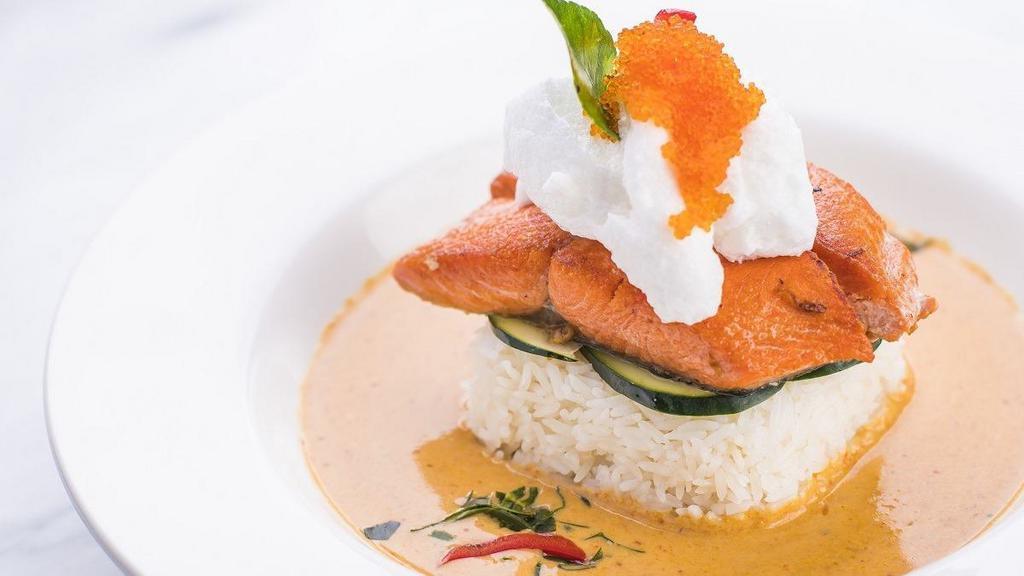 Salmon Curry · Grilled salmon filet atop jasmine rice, cucumber, and our signature red curry which includes onions, kaffir lime leaves, and bell peppers. Topped with whipped coconut milk, tobiko, and a kaffir lime leaf.
