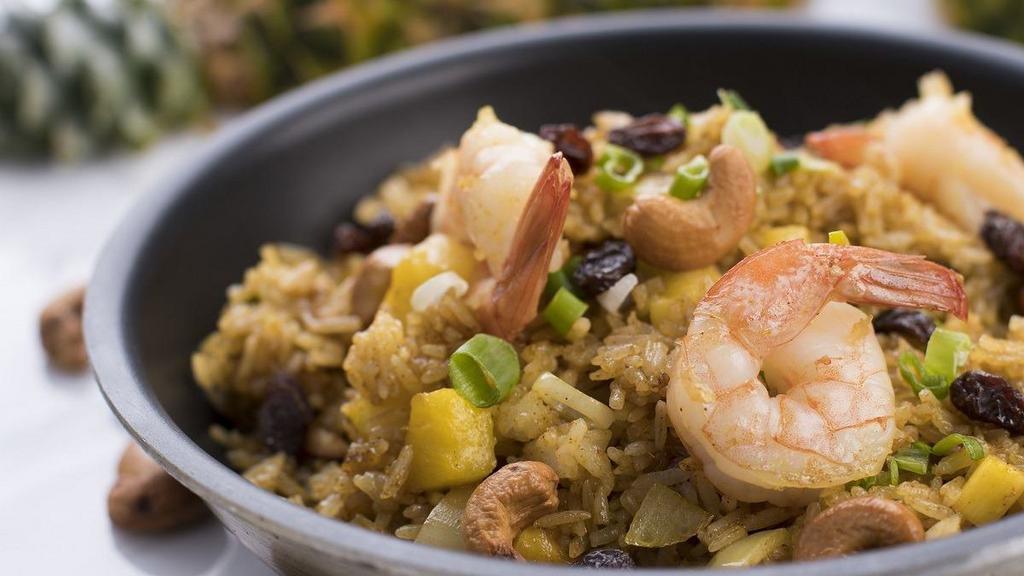 Pineapple Fried Rice · Jasmine rice infused with yellow curry flavor, stir-fried with pineapple, egg, cashew nuts, raisins, and onions. Choice of chicken, pork, or tofu, beef, shrimp, and seafood for an additional charge.