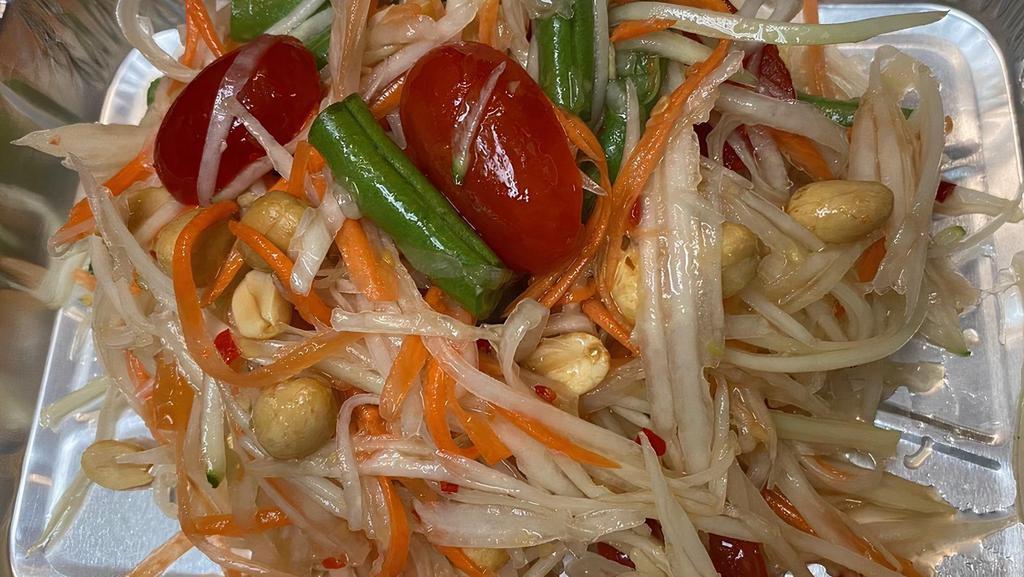 Papaya Salad (Som Tum) · Thai signature spicy salad with shredded green papaya, carrots, green beans, fresh chills, garlic, tomatoes and roasted peanuts tossed in fish sauce lime juice dressing. Spicy.