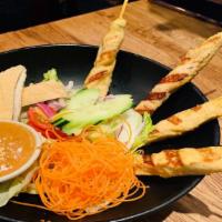 Y07=Chicken Satay Salad · Grilled chicken satay served with peanut sauce on the side, cherry tomato, iceberg, carrots,...