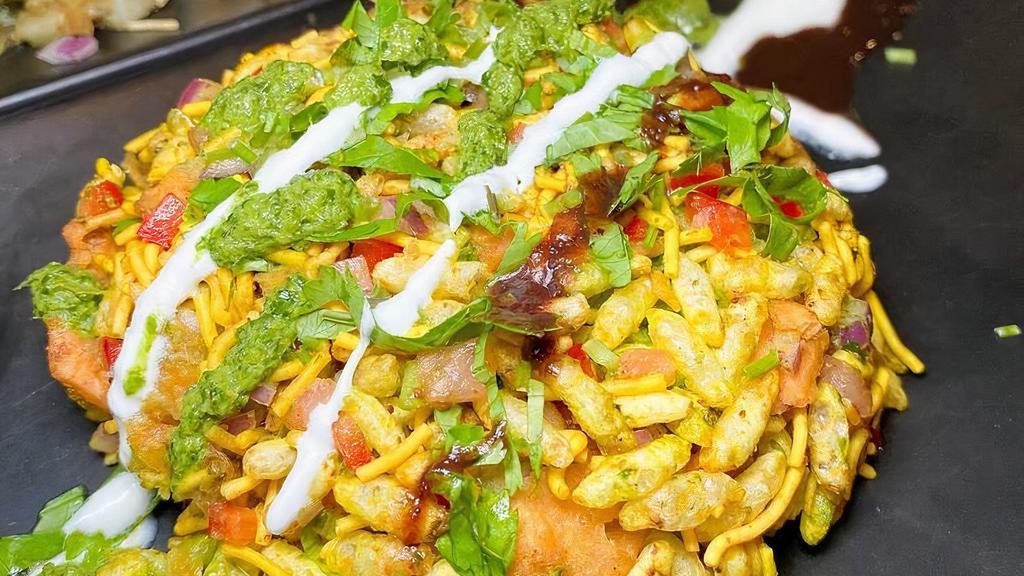 Bhel Poori · Spiced puffed rice tossed with tomatoes, onions, cilantro, sev, tamarind and cilantro-mint chutney