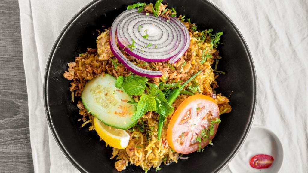 Chicken Biryani · Layering marinated chicken with basmati rice along with our homemade herbs, saffron milk & ghee. Served with raita, fresh cut onion, cucumber and chili on the side.