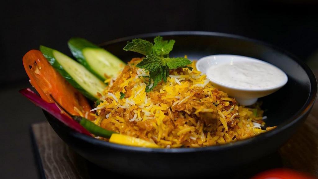 Shrimp Biryani · Layering marinated chicken with basmati rice along with our homemade herbs, saffron milk & ghee. Served with raita, fresh cut onion, cucumber and chili on the side.