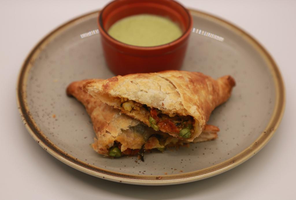 Paneer Puff · Crumbled spiced Paneer (Indian Cheese) with roasted peppers and Peas. Served with Mint Ranch Sauce